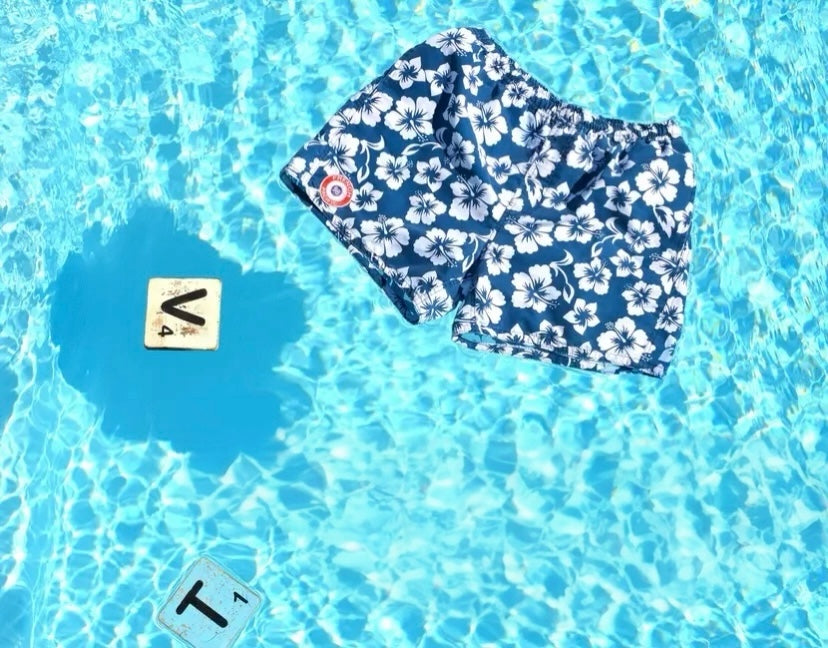 Men's short swim briefs with hibiscus print.